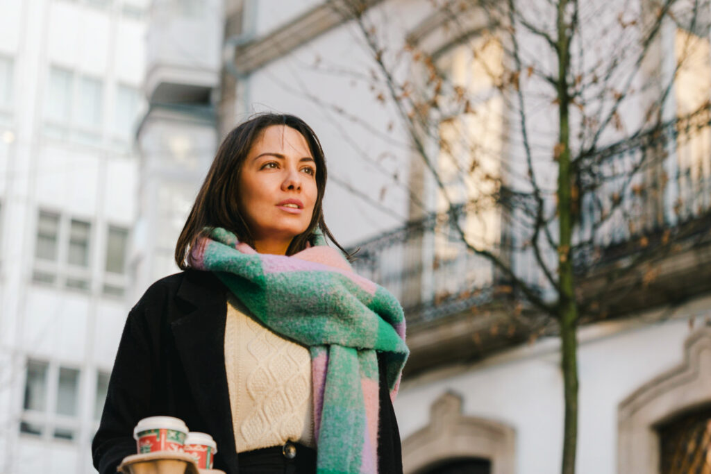 Mujer modelo con café para llevar en ciudad